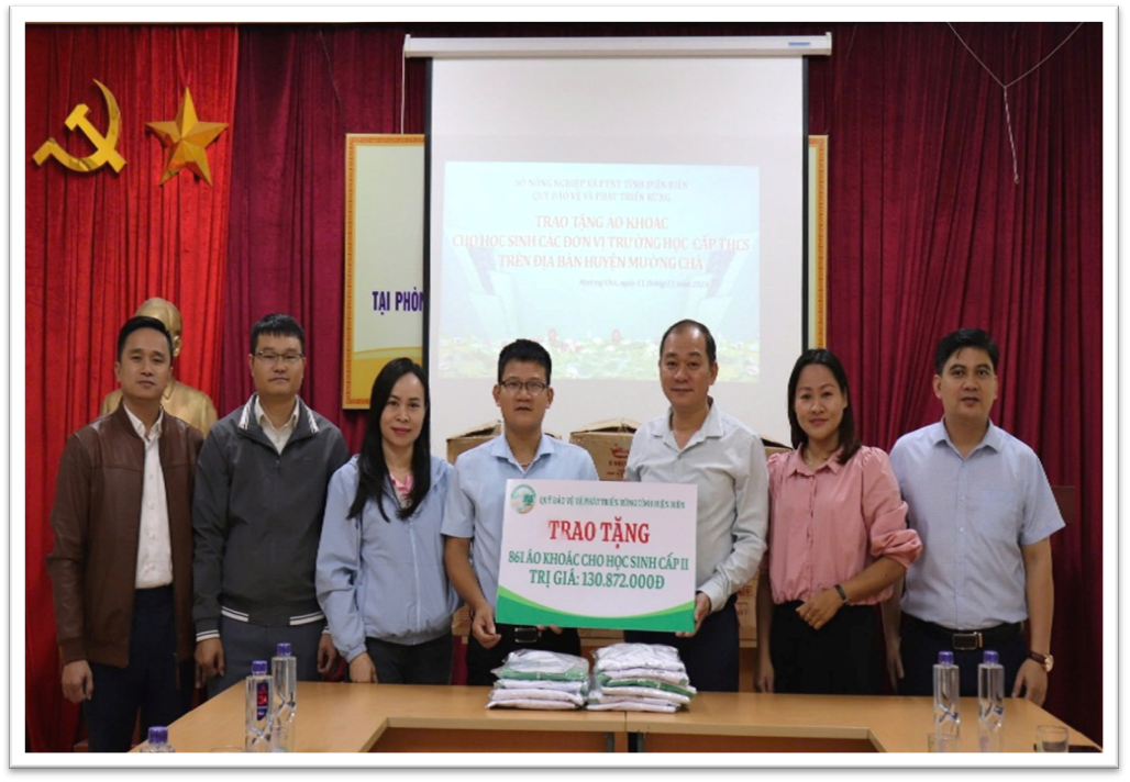 Ông Phan Anh Sơn, Phó Giám đốc Quỹ Bảo vệ và Phát triển rừng tỉnh trao áo khoác cho học sinh Trường PTDTBT THCS Huổi Mí tại Phòng GD&ĐT